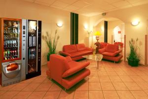 特里尔Hotel Constantin的大堂设有红色椅子和饮料机