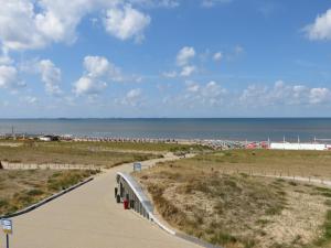 滨海卡特韦克Appartementen Zeezicht的通往海滩的步道,以大海为背景