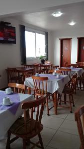 里奥格兰德Hotel São Paulo的用餐室配有带白色桌布的桌子