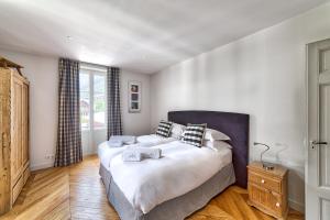 夏蒙尼-勃朗峰Marie Paradis Apartment的一间卧室设有一张大床和一个窗户。