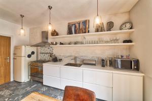 夏蒙尼-勃朗峰Marie Paradis Apartment的厨房配有白色橱柜和白色冰箱。