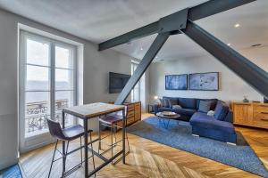 夏蒙尼-勃朗峰Marie Paradis Apartment的客厅配有蓝色的沙发和桌子