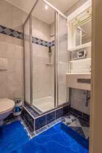 上陶恩Party Hotel Taverne的带淋浴的浴室和蓝色地板。