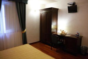 锡拉库扎泰欧克里托酒店的一间卧室配有书桌、橱柜和床。