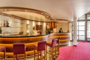 弗莱堡茵维特洛文弗赖堡酒店的餐厅设有1间带紫色椅子的酒吧