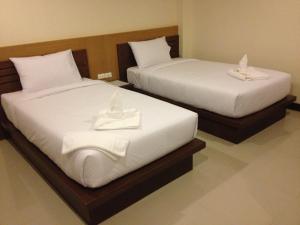 清莱清莱科迪莉亚酒店的两张带白色床单和毛巾的床