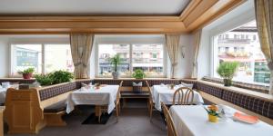 奥蒂塞伊Hotel Garni Planaces的餐厅设有2张桌子和2个窗户