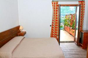 维克艾库塞Villa Rosa di Nonna Rosa的一间卧室设有一张床,并有通往阳台的门