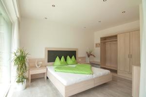 卡斯泰尔贝洛Weinreichhof的一间卧室配有一张带绿色枕头的床。