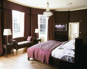 斯劳斯托克广场酒店的一间卧室配有一张床、一张沙发和一把椅子