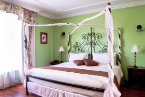 基多卡萨阿利索精品酒店的一间卧室配有一张带天蓬的白色床