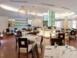 吉隆坡吉隆坡丝卡梅淘瓦酒店的餐厅配有白色的桌椅和灯光