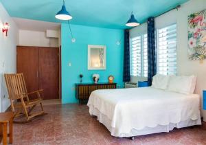 圣胡安La Esmeralda PR的卧室配有白色的床和蓝色的墙壁