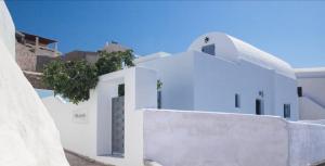 梅萨雷亚Villa Del Sol Santorini的一座白色的建筑,上面有一棵树