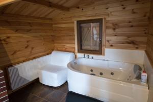 尤斯托尼莫斯基Domki Luksusowe Eskada的木制客房内的白色浴缸浴室