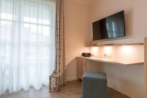 伯尔格伦德-雷特维施Appartement Mittsommer的客房设有电视、椅子和窗户。