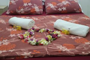 帕皮提马哈纳小屋＆背包客旅舍的一张带两张滚毛巾和鲜花的床
