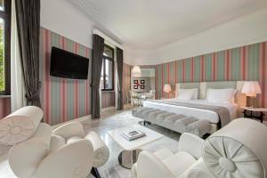罗马罗马皇宫大酒店的酒店客房配有床、椅子和电视。