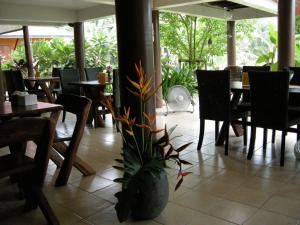 大城班泰酒店的一间设有桌椅和盆栽的餐厅