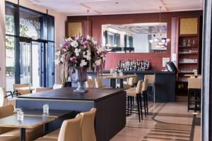 里尔欧洲里尔装饰艺术酒店的一间带桌椅和鲜花柜台的餐厅