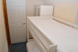 斯托诺韦Flat 14c Bayhead的一间小卧室,配有两张双层床和一扇门