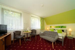 霍尔兆Berghotel Talblick的酒店客房设有沙发、床和桌子。