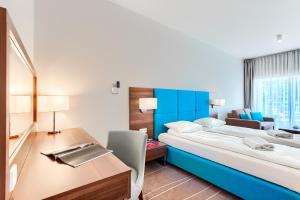 米兹多洛杰Apartamenty AmberHome的酒店客房设有一张大床和一张书桌。