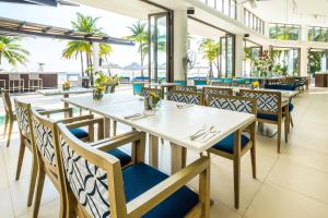 长滩岛长滩岛探索海滩度假村的餐厅设有白色的桌子和蓝色的椅子