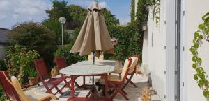 CordemaisGîte Mido的庭院内桌椅和遮阳伞
