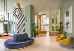 马德里马德里巴塞罗塔酒店的大堂设有蓝色的沙发和雕像