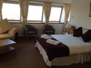 因弗内斯史密斯顿酒店的酒店客房带两张床、一张沙发和窗户。