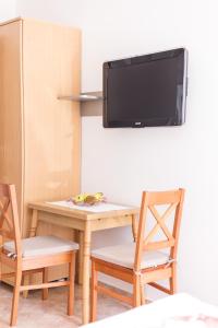 沃迪切华伦天奴公寓酒店的一张桌子和椅子,墙上有电视