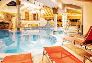 图克斯Hotel Neuhintertux的游泳池,酒店内设有椅子和游泳池