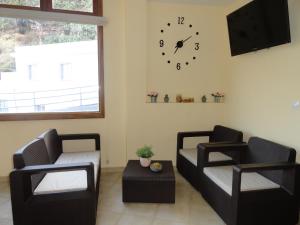 ImadaHotel Rural Imada的客厅配有两把椅子和墙上的时钟