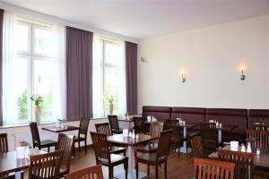 汉堡汉堡市中心诺瓦姆酒店的用餐室设有桌椅和窗户。