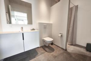 霍尔斯特布罗Hotel Phønix的白色的浴室设有卫生间和水槽。