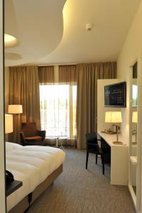 乌登Hotel Udens Duyn的配有一张床和一张书桌的酒店客房