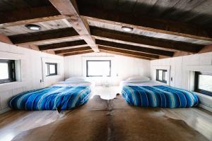 奥海Caravan Outpost的一间设有两张蓝色大床的房间