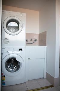 梅林布拉棕榈公寓的厨房里配有白色的洗衣机和烘干机