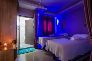 坎帕拉Nyumbani Hotel的一间设有两张床和蓝色灯光的房间