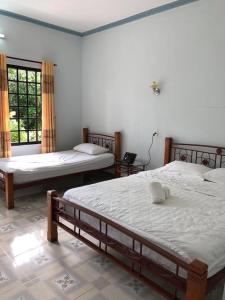 美奈Bí Homestay的一间卧室设有两张床和两个窗户。