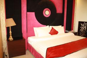 穆里Shangrila Hotels and Resort的一间卧室配有一张带粉色和黑色床头板的床