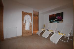 伊施格尔芭芭拉公寓的一间设有白色椅子的房间和一扇带浴袍的门
