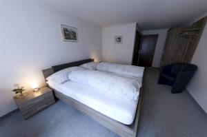 穆奥塔塔尔Gasthaus Post的一间卧室配有一张带床头柜和椅子的床