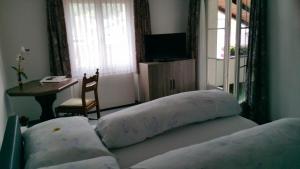 穆奥塔塔尔Gasthaus Post的一间卧室,床上配有两个枕头,一张桌子