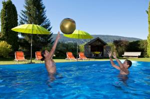 玛丽亚普法尔Landschützer's Country Suites的两人在游泳池玩球