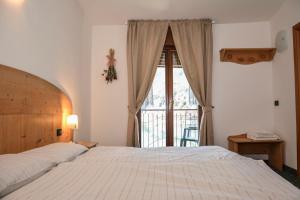 梅佐拉戈艾尔伯格梅佐拉戈酒店的一间卧室设有一张床和一个大窗户