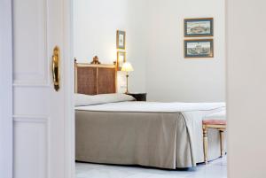 赫雷斯-德拉弗龙特拉赫雷斯别墅酒店的一间白色客房内的床铺卧室