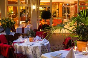 菲林根-施文宁根瑞登姆勒罗曼蒂克酒店的餐厅设有餐桌,配有白色桌布和植物
