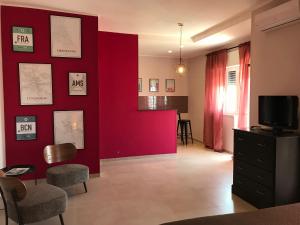 奥斯图尼Apartment Antonella的客厅设有红色的墙壁和电视。